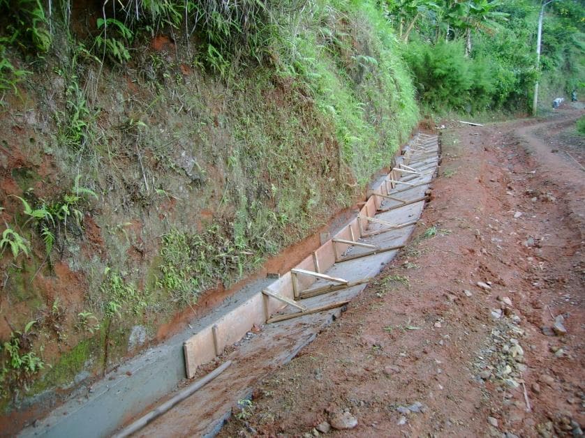 Canaleta en concreto en construcción al pie de un talud en zona rural