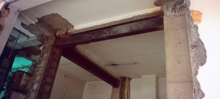 Pórtico de concreto descubierto y reforzado con perfilería metálica en la clínica