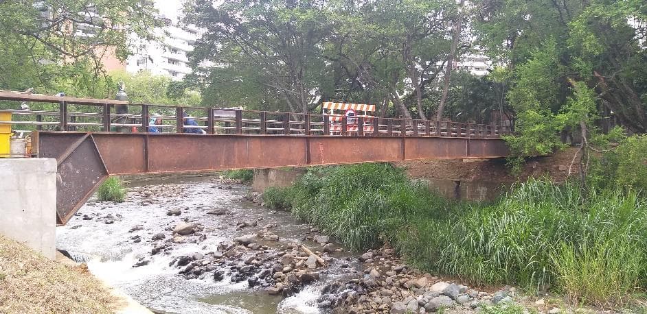 Puente peatonal metálico sobre el río Cali terminado, visto desde la ribera